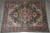 10'9" x 14'1" hand-knotted wool rug shown flat on grey tile floor in warehouse
