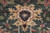 Golden pendant motif on green field with navy accents and dense hand-knotted wool pile