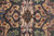 Center medallion close-up with ivory, gold, navy and burgundy geometric drawing and visible knots