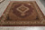Angled showroom view of 8x10 hand-knotted Mahi rug with scalloped medallion and ivory border