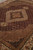 Diagonal view highlighting silk sheen across the burgundy herati field and beige medallion surround