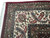 Corner close-up of ivory main border with red palmettes, sage leaves and white cotton fringe