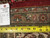 Back of the rug with inventory tag number 6385 and tape measure showing fine knot density