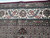 Border detail showing burgundy selvage, taupe guard bands and ivory floral vine of the wool silk rug
