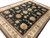 Corner perspective of black and ivory wool and silk rug showing silk highlights on cream blossoms