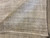 Rug folded back to reveal the tight hand-knotted weave and warm taupe gray tones