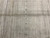 Vertical column of tiny cross and square motifs running through the silver gray field