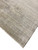 Corner of the contemporary Indian wool rug showing the finished selvage and neutral gray pile