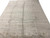 Angled floor view of the large neutral gray Gabbeh rug with a dotted cross motif row
