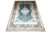 Angled view of the teal and ivory silk rug showing lustrous sheen and gold border