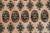 Close-up of octagonal guls and diamond stars woven in sage green, rust and ivory wool