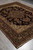8' x 10'2" Jaipur wool rug photographed at an angle, dark burgundy field with gold border