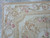 Corner close-up showing flat tapestry weave, camel gold guard border and blush rose garland detail