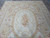 9 by 12 Aubusson rug photographed from above showing cream field and oval floral cartouche