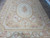Full length view of beige Aubusson area rug with medallion, corner cartouches and floral outer border