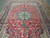 Traditional living room size wool rug showing symmetrical palmettes, curling vines and ivory guard stripes