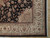 Corner detail of ivory palmette border framing black floral field with burgundy outlines and cotton fringe
