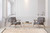 Cream Moroccan wool rug anchoring a bright living room with grey armchairs and gold coffee table