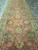 4'2 x 18'6 runner rug viewed lengthwise on stone tile, dusty rose field with gold accents
