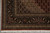Corner view with black border palmettes, ivory spandrel lattice and clean selvage above the fringe