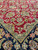 Sage green guard border separating burgundy floral field from black border with orange and gold blossoms