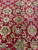 Traditional all-over floral drawing in soft green, ivory and saffron across a deep wine red ground