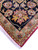 Close-up corner detail showing ivory fringe, sage minor border and gold palmette on black ground