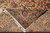 Folded corner revealing tight cotton foundation, ivory fringe and a small woven bird motif