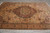 Rust and green medallion glowing under gallery lighting on this hand-knotted Turkish wool rug