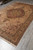 Full 7'8" x 12' wool rug photographed at an angle on showroom tile flooring