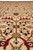 Pile-level view of ivory field motifs, red arabesques and soft sage green floral accents