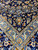 Border corner detail with sky blue main band, palmettes and scrolling arabesque vines on navy