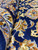 Folded pile detail showing soft wool nap, navy ground and rust, ivory and sky blue flowers
