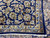 Corner turned back revealing tight hand-knotted cotton foundation behind the navy and ivory floral border