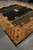 Angled view of contemporary Gabbeh rug highlighting saffron corner cartouche and dark outer edge