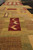 Border detail showing zigzag burgundy block, olive squares and hand-knotted wool pile texture