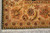 Corner detail of the ivory main border with coral leaves, green vines and black guard stripe