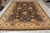 Full length view of large Indian wool rug with ivory border and cream cotton fringe
