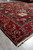 Corner of the 10'8" x 12'4" garden rug on tile floor with ivory cotton fringe