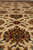 Floor-level view of beige field palmettes worked in olive green, garnet red and gold