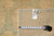 Back of rug with handwritten tag reading 9.3 x 11.8 beside a measuring tape