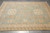 9' x 11'9" wool rug viewed lengthwise, camel border framing the pale sky blue field