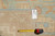 Reverse of the rug with woven origin tag and tape measure placed for pile scale