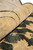 Rolled edge close-up showing dense pile, black sickle leaves and warm apricot border tones