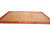 Distant perspective of room size transitional area rug in rust and gold on white background