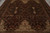 Close overhead angle of the 9x12 wool rug's ivory corner cartouches and olive vinework
