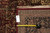 Back of rug with hangtag and tape measure confirming knot density and 9x12 dimensions
