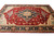 10x14 Serapi design rug viewed lengthwise, camel guard bands framing deep indigo main border