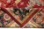Folded corner revealing even hand-knotted back, cotton foundation and clean navy border weave
