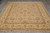 Angled floor shot showing all-over floral layout, soft camel ground and wide ivory border